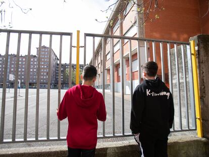 Two students look at a closed school in the Basque city of Vitoria during the coronavirus lockdown.