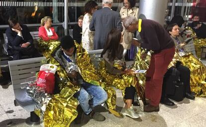 Grupos de pasajeros arropados con mantas térmicas en la estación de Calais (Francia), el 2 de septiembre de 2015.