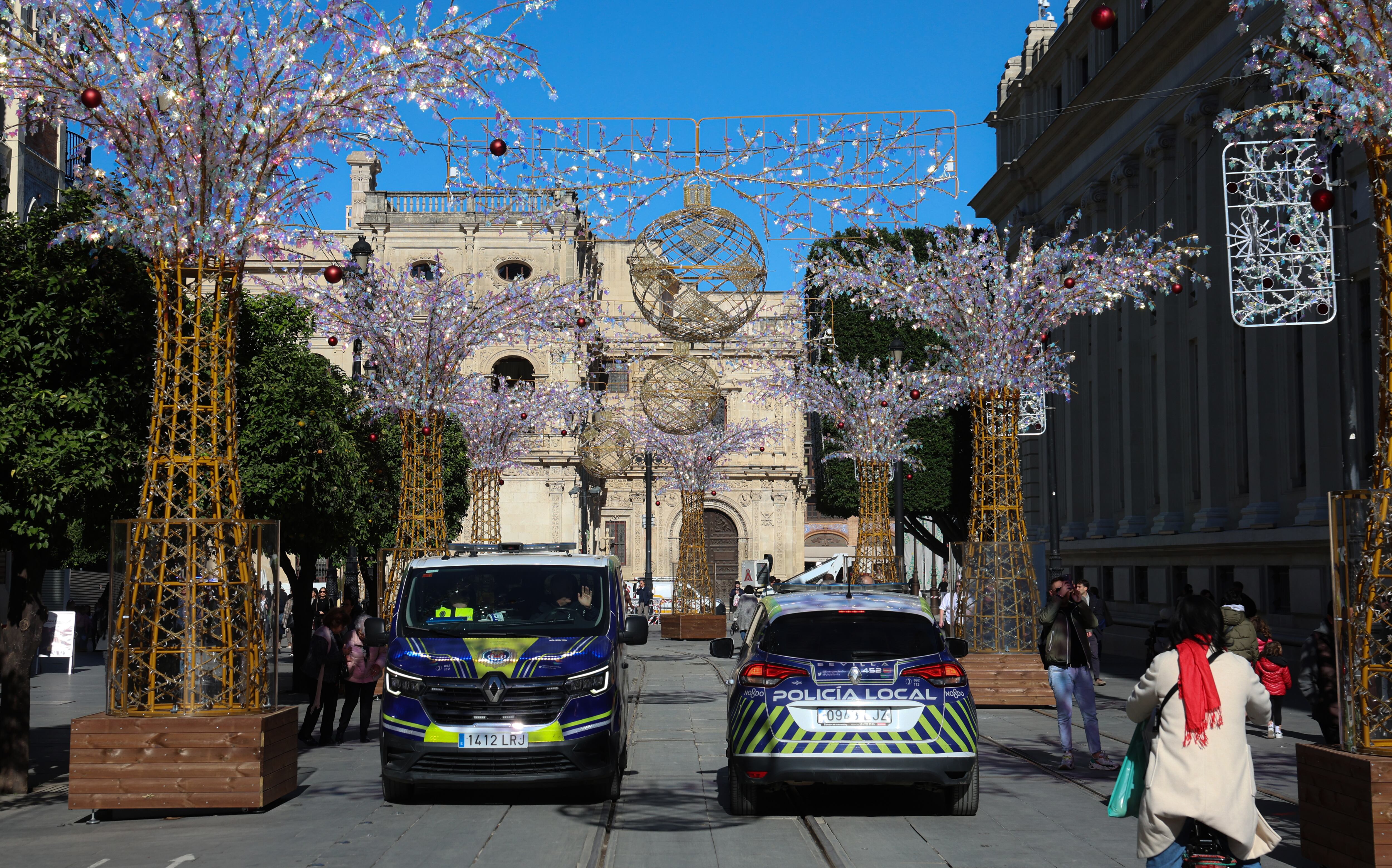 Vehículos de la Policía Local de Sevilla patrullan por la avenida de la Constitución entre ambiente navideño 