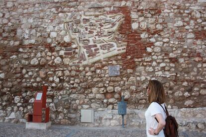 Una turista mira el mapa del pueblo de Hita que está dibujado entre las piedras de las fachadas de la plaza. Es un mural de cerámica pintado por la vecina Felisa Rojo a finales de los 90.