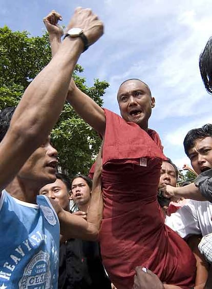 Varios manifestantes levantan a un monje coreando lemas contra el Gobierno, ayer en Yangon.