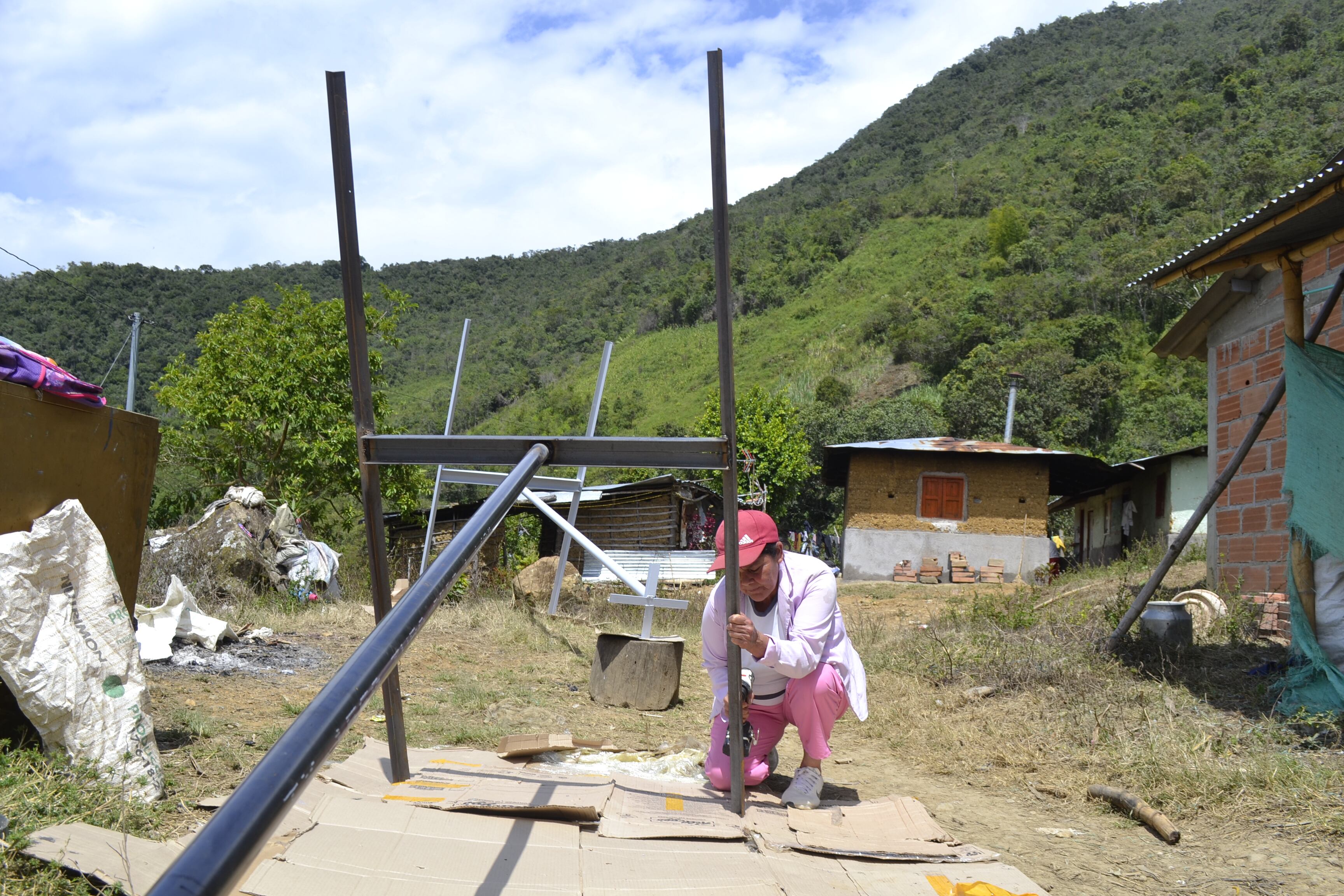 Franquelina David taladra hoyos en la estructura metálica que sostendrá un panel solar.