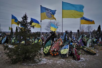 Banderas ucranias ondean en el cementerio de Bucha, este viernes. 
