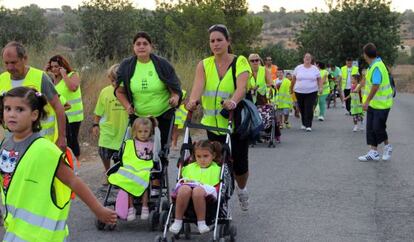 Madres, padres y alumnos de La Pobla de Vallbona, de camino al colegio al tiempo que protestan por la falta de autobús.