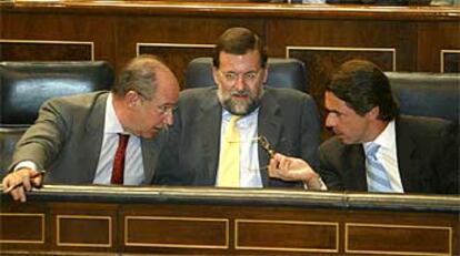 José María Aznar conversa en el Congreso con Rodrigo Rato y Mariano Rajoy.