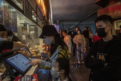 Una fila de clientes frente a un negocio de comida rápida en Wuhan, el 6 de abril. Hay mascarillas, pero poca distancia de seguridad.