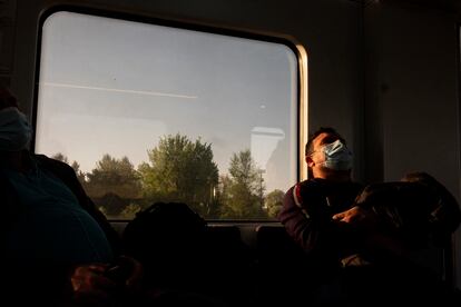 Un pasajero duerme en el interior de un vagón de la línea C-7 de Renfe que une Alcalá de Henares y Atocha.
