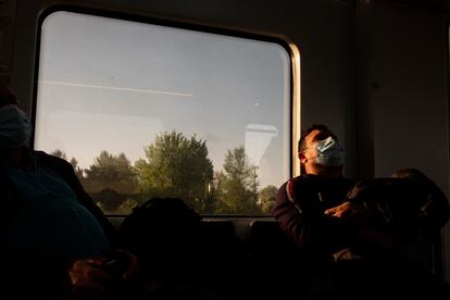 Un pasajero duerme en el interior de un vagón de la línea C-7 de Renfe que une Alcalá de Henares y Atocha.