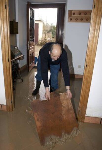 Un hombre intenta vaciar el agua de su casa en el pueblo de Arkaute.