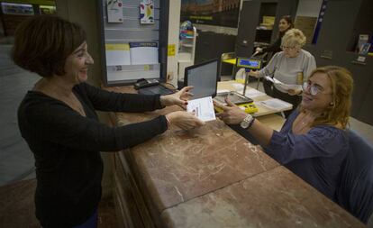 Una mujer vota por correo en una oficina de Sevilla.