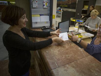 Una mujer vota por correo en una oficina de Sevilla.