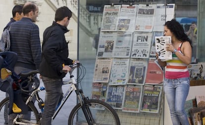 Tres viandantes observan las portadas de la prensa que informan sobre el comunicado en que la banda ha anunciado el fin de la lucha armada. La joven de la izquierda sostiene un ejemplar de 'El Diario Vasco', en la parte vieja de San Sebastián.