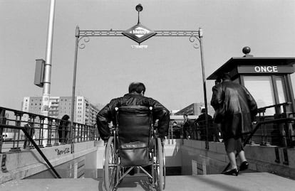 Un minusválido en silla de ruedas ante las escaleras de acceso de una boca del metro de Plaza de Castilla (Madrid), a la derecha un quiosco de la ONCE. 08/02/1992