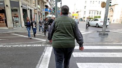 Un hombre con sobrepeso cruza, este mediodía, una calle del centro de Valencia.
