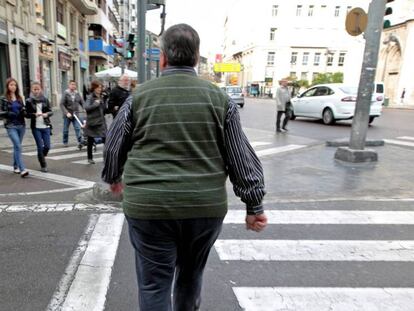 Un hombre con sobrepeso cruza, este mediodía, una calle del centro de Valencia. 