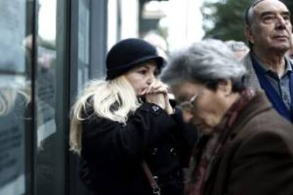 Varias personas hacen cola a las puertas de las oficinas de la Fundación Nacional de la Seguridad Social en el barrio de Kakkithea, en Atenas (Grecia), el pasado martes.