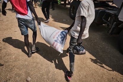 Dos jóvenes cargan un saco de sorgo con la inscripción de USA en la bolsa. La congelación de fondos de USAID ha afectado directamente a millones de personas en todo el mundo, especialmente en contextos de primera necesidad como Sudán del Sur.