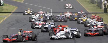Lewis Hamilton, a la izquierda, toma la primera curva de la carrera. A la derecha, por delante de Raikkonen, el Renault de Alonso.