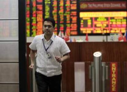 Un corredor de bolsa filipino camina por la sede de la Bolsa de Filipinas (PSE) en la ciudad de Makati, al sur de Manila. EFE/Archivo