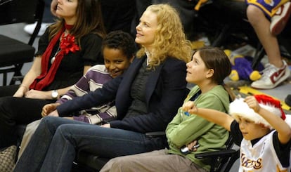 Nicole Kidman flanqueada por los dos hijos que adoptó junto a Tom Cruise, Isabella y Connor, en un partido de baloncesto en diciembre de 2004 en Los Ángeles.