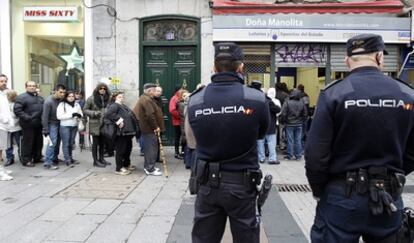 Agentes de la Policía Nacional vigilan la Administración de Loterías Doña Manolita.