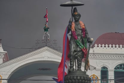 Un manifestante sostiene la bandera de Nepal encima del Palacio Singha Durbar, sede del gobierno y el parlamento en Nepal.
