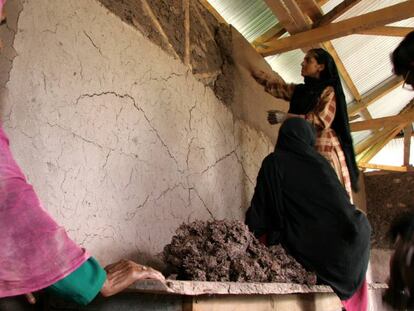 Unas mujeres reparan su casa en Pakist&aacute;n. 