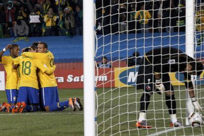 Bravo, el portero chileno, recoge el balón de la red mientras los brasileños celebran el primer gol.