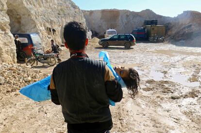 Un hombre lleva en brazos el cadáver de un niño en Siria.