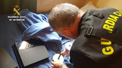 Un Guardia Civil, con material incautado en una operaci&oacute;n contra la pornograf&iacute;a infantil. 