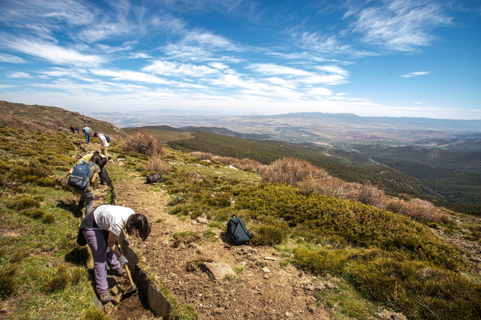 Varios trabajadores y voluntarios excavan para recuperar una de las acequias de época nazarí del área de Granada.