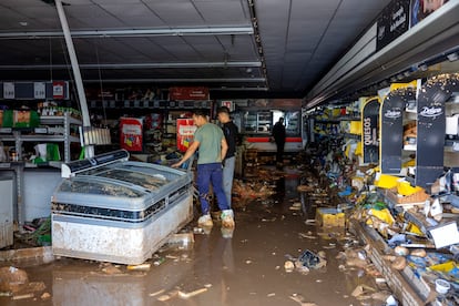 Varias personas dentro de un supermercado inundado por la dana, este jueves en Sedav. 