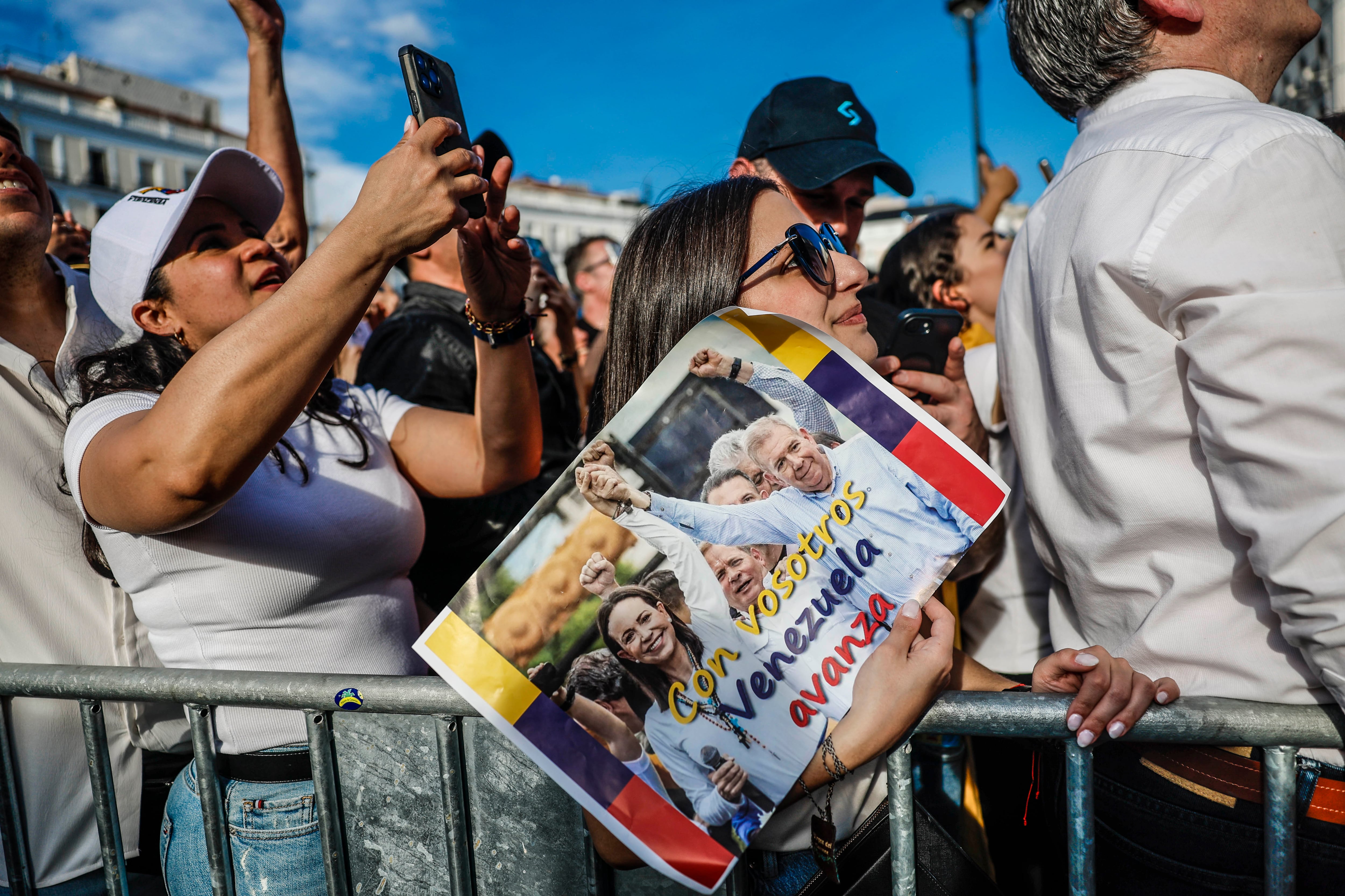 Una mujer sostiene una imagen de María Corina Machado y Edmundo González, el sábado en la Puerta del Sol de Madrid.
