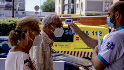 A health worker checks the temperature of residents in Villaverde, Madrid.
