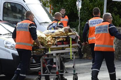 Los servicios de emergencia trasladan a uno de los heridos en el accidente ocurrido al chocar frontalmente un autocar que transportaba jubilados con un camión en una carretera departamental de Puisseguin, cerca de Burdeos (Francia).