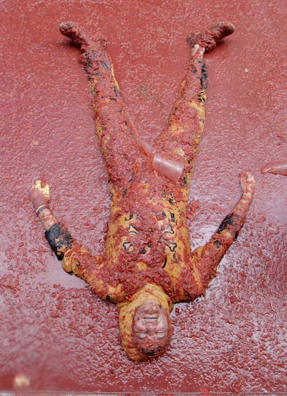 Participante en la fiesta La Tomatina tendido en el suelo.