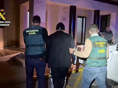 Dos guardias civiles trasladan, tras su detención este domingo, al último tripulante de la narcolancha que mató a dos guardias en Barbate (Cádiz) en febrero de 2024, en una imagen facilitada por el instituto armado.