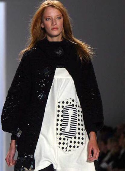 Una modelo desfila con un minivestido blanco y una chaqueta de lana de Custo en Nueva York.