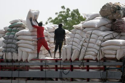 Dos hombres cargan sacos de maíz en el mercado de Jibia (Nigeria). 