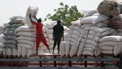Dos hombres cargan sacos de maíz en el mercado de Jibia (Nigeria).