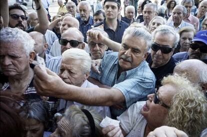 Pensionistas aguardan su turno ante una sucursal bancaria en Atenas.