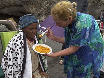 Una mujer da de comer a una de las inmigrantes llegadas a la playa de Jacomar.