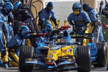 Fernando Alonso, rodeado de operarios.