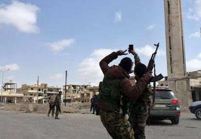 Unos soldados sirios se hacen una foto en una calle de la ciudad nueva de Palmira tras los combates en los que han ganado al grupo yihadista del Estado Islámico que ocupaba la ciudad siria, el 28 de marzo de 2016.