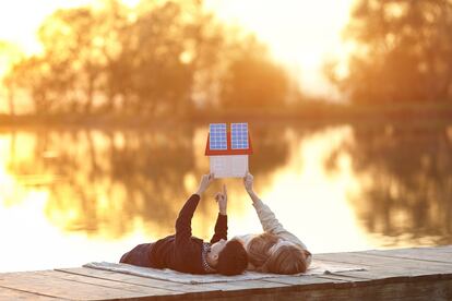 Happy couple of children dreaming of a house with solar panels