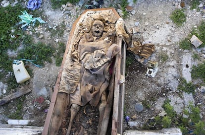 Los restos de un cadáver exhumado permanecen en el suelo antes de que los trabajadoes lo trasladen a una fosa común del cementerio nacional de Puerto Príncipe, en Haití.