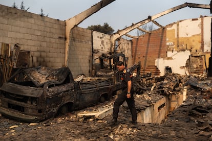 Un trabajador de Protección Civil, en una nave arrasada por el fuego este lunes.