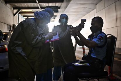 El personal sanitario registra a un guardia de seguridad en busca de síntomas de covid-19, en un hospital de Bangkok. Las autoridades tailandesas han informado este lunes de que se ha registrado una cifra récord de contagios tras sumar 745 casos de coronavirus en el último día.