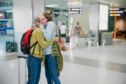 Una madre se despide de su hija en el aeropuerto.