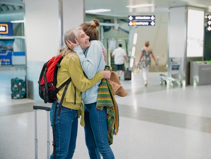 Una madre se despide de su hija en el aeropuerto.